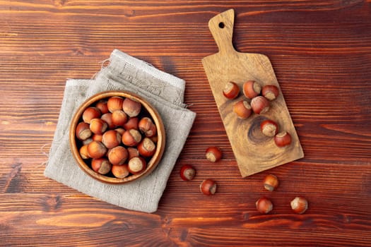 Hazelnuts on wooden table. Heap or stack of hazelnuts. Flat lay