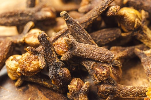 Dry cloves in wooden background. Cloves spice. Close up macro.