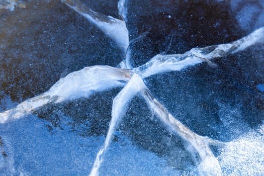 Cracked ice texture. Frozen lake water in winter. Selective focus