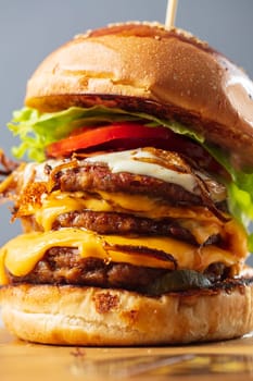 Loaded cheeseburgers three triple, stacked patties stacked high with layers of cheese, lettuce, and tomato. Tall cheeseburger. High quality photo
