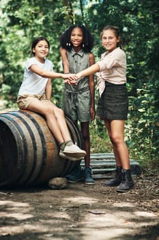 Sharing new experiences with new friends. a group of teenage girls joining their hands in solidarity at summer camp