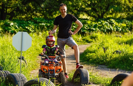 A child rides a quad bike through the mud. ATV rider rides.