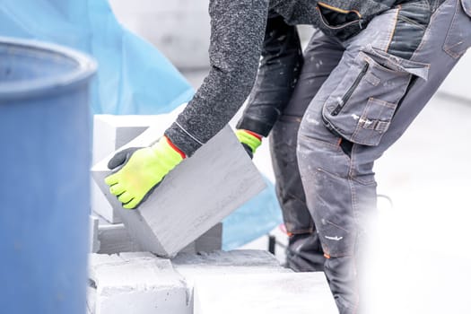 craftsman builds a house from concrete bricks. High quality photo