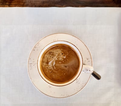 Top view of a cup of Cafe Crema on a white doily
