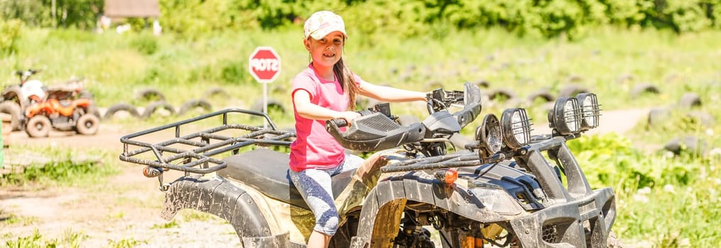 Little girl riding ATV quad bike in race track