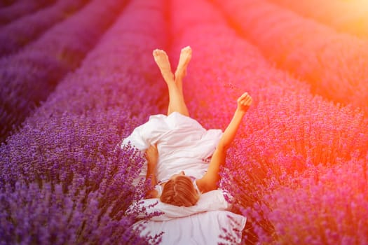 Woman lavender field. A middle-aged woman lies in a lavender field and enjoys aromatherapy. Aromatherapy concept, lavender oil, photo session in lavender.