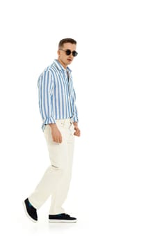 Smiling happy confident man in sunglasses and in casualwear standing isolated on white background. full length.