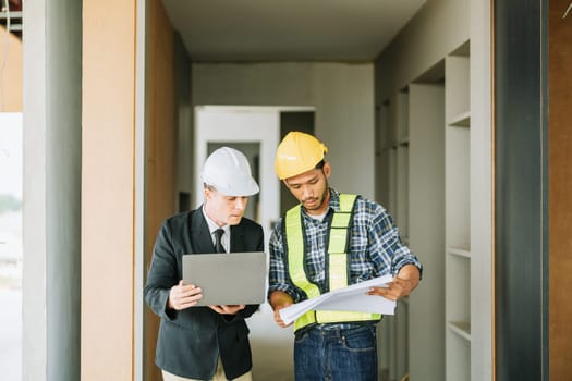 multi ethnic engineer brainstorming and measuring for cost estimating on blueprint and floor plan drawings about design architectural and engineering for houses and buildings.