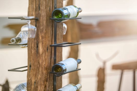 Wine storage holder made of wood and metal rustic style. Wine bottles are arranged on a holder with copy space. The concept of collecting alcoholic beverages. High quality photo