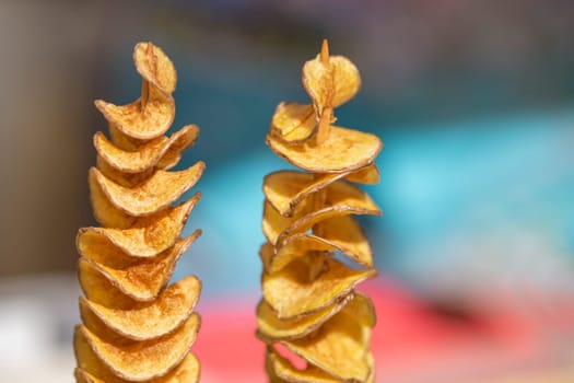 The process of making potato chips at home. Potato finely chopped into thin slices fried until crispy in sunflower oil. Organic potato chips. High quality photo