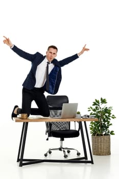 Satisfied young businessman gesturing emotionally and celebrating victory in the office
