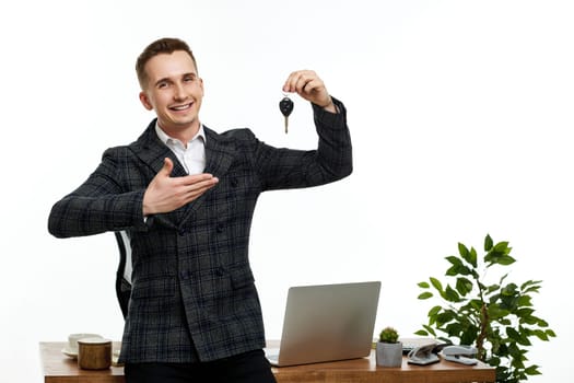 handsome caucasian businessman holding keys in the office. Car dealerships offer car . Car insurance. copy space