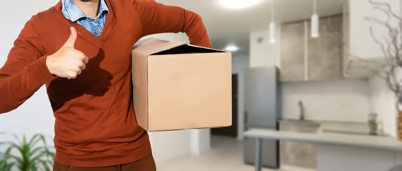 young man carries moving boxes.