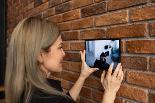 Protection of private residential building with help of an external video surveillance system. an application on smartphone screen. CCTV view of burglar breaking into home.