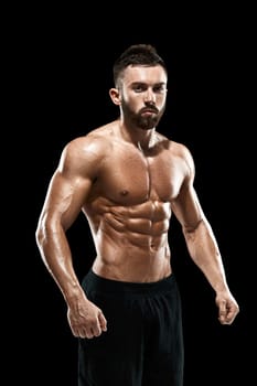 Muscular bodybuilder guy doing posing over black background.