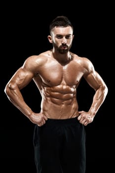 Muscular bodybuilder guy doing posing over black background.