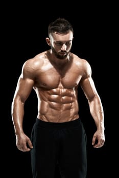 Muscular bodybuilder guy doing posing over black background.