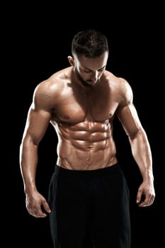 Muscular bodybuilder guy doing posing over black background.