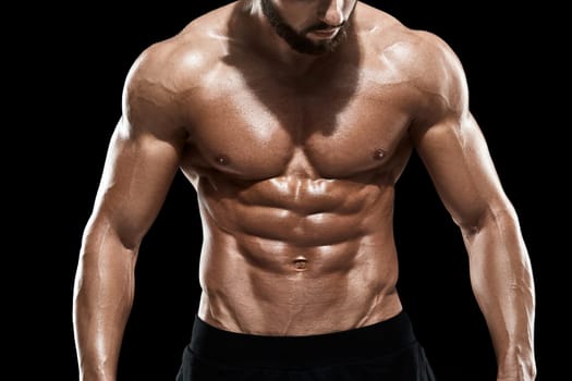 Muscular bodybuilder guy doing posing over black background. Close up