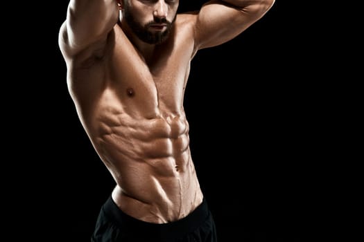 Muscular bodybuilder guy doing posing over black background. Close up