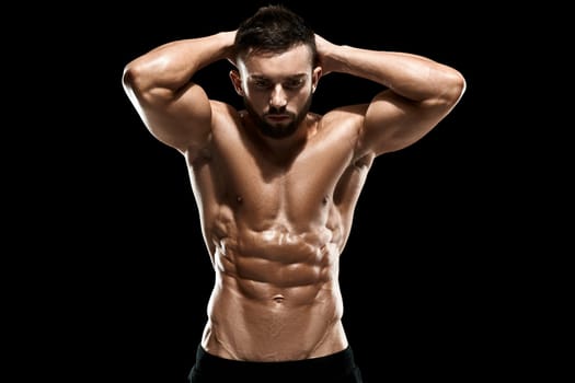Muscular bodybuilder guy doing posing over black background.