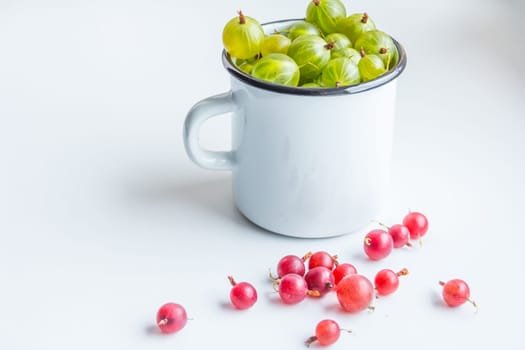 Set of organic gooseberry. Gooseberries fruits in a cup. Green gooseberry over rustic wooden background.