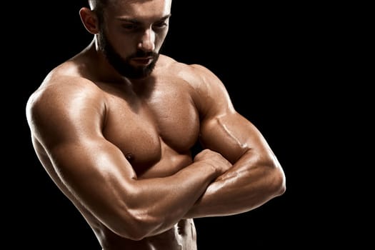 Muscular bodybuilder guy doing posing over black background. Close up