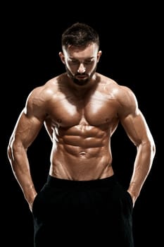 Muscular bodybuilder guy doing posing over black background.