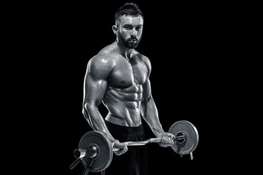 Close up of young muscular man lifting weights over dark background. Black and white color