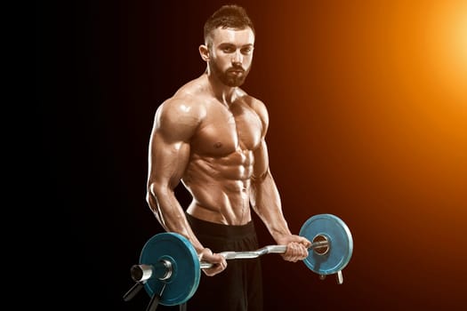 Close up of young muscular man lifting weights over dark background. with sun flare