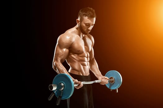 Close up of young muscular man lifting weights over dark background. with sun flare