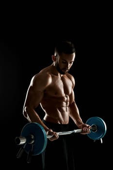 Close up of young muscular man lifting weights over dark background