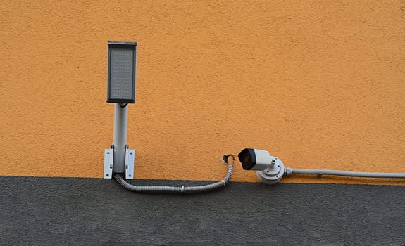 camera for security with lamp on house wall.