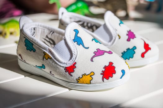 Pair of baby sneakers on wood plank background