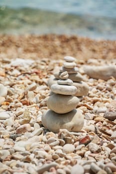 Smooth stones stacked on each other on the beach. Tower of stones for meditation on a sea.