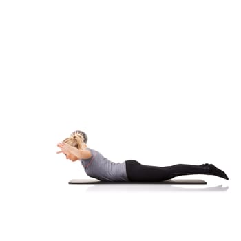 Feeling her muscles work. A young woman working out with an exercise ball while isolated on a white background