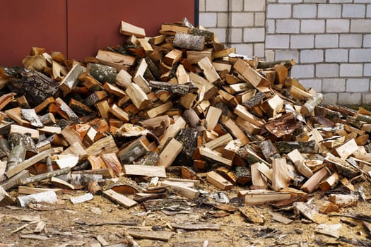 Dry chopped firewood in a pile near the wall.