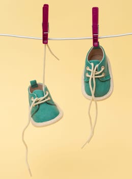 Tiny baby shoes hanging on the clothesline. Newborn concept