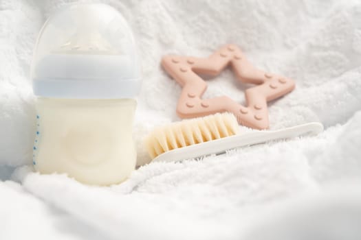 Several attributes of a newborn milk bottle toy and soft brush.