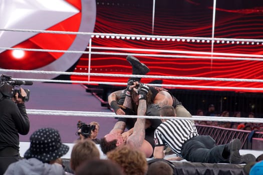 Santa Clara, California - March 29, 2015: The Undertaker returns to the ring after a year of absence and defeats Bray Wyatt in a thrilling match at Wrestlemania 31. The legendary wrestler shows his dominance by locking Wyatt in his signature move, the Hells Gate, a modified gogoplata that chokes the opponent with the shin. Wyatt tries to resist but eventually taps out, giving The Undertaker his 22nd victory at the grandest stage of them all.