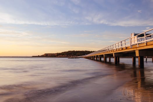 A view of the famous causeway leading to Granite Island Recreation Park at sunrise in Victor Harbor on a sunny autumn day in South Australia, Australia