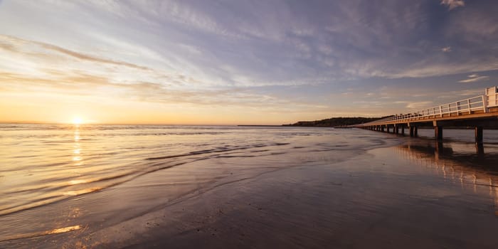 A view of the famous causeway leading to Granite Island Recreation Park at sunrise in Victor Harbor on a sunny autumn day in South Australia, Australia