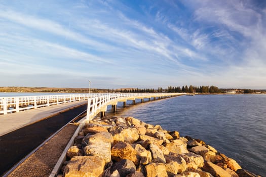 A view of the famous causeway leading to Granite Island Recreation Park at sunrise in Victor Harbor on a sunny autumn day in South Australia, Australia