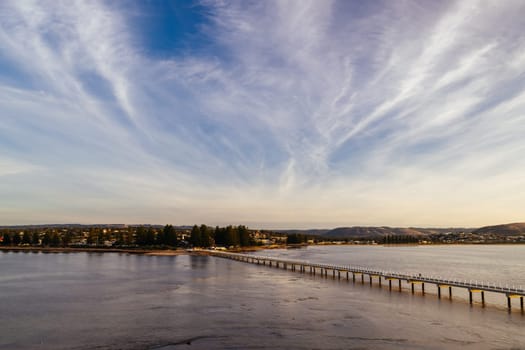 A view of the famous causeway leading to Granite Island Recreation Park at sunrise in Victor Harbor on a sunny autumn day in South Australia, Australia