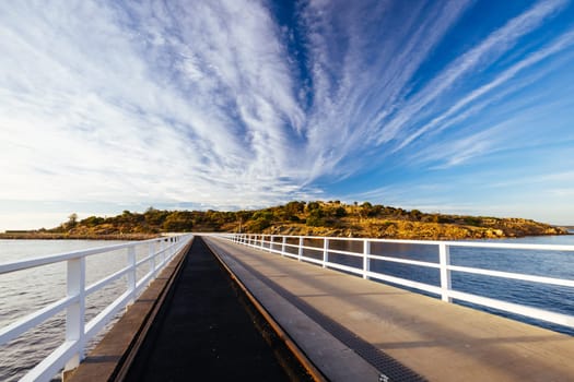 A view of the famous causeway leading to Granite Island Recreation Park at sunrise in Victor Harbor on a sunny autumn day in South Australia, Australia