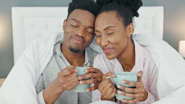 Coffee, bed and couple with a man and woman in the bedroom to relax in their home together. Drink, tea and romance with a young male and female sitting in their house in the morning over a weekend.