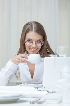 Business woman drinking coffee in restaurant, close-up