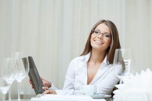 Cute smiling woman in glasses works on notebook, close-up