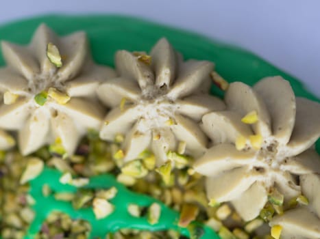 studio shot of green pistachio frosted dripped icing cup cake