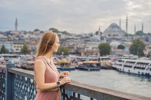 Young tourist woman on Galata bridge, Golden Horn bay, Istanbul. Panorama cityscape of famous tourist destination Bosphorus strait channel. Travel landscape Bosporus, Turkey, Europe and Asia.